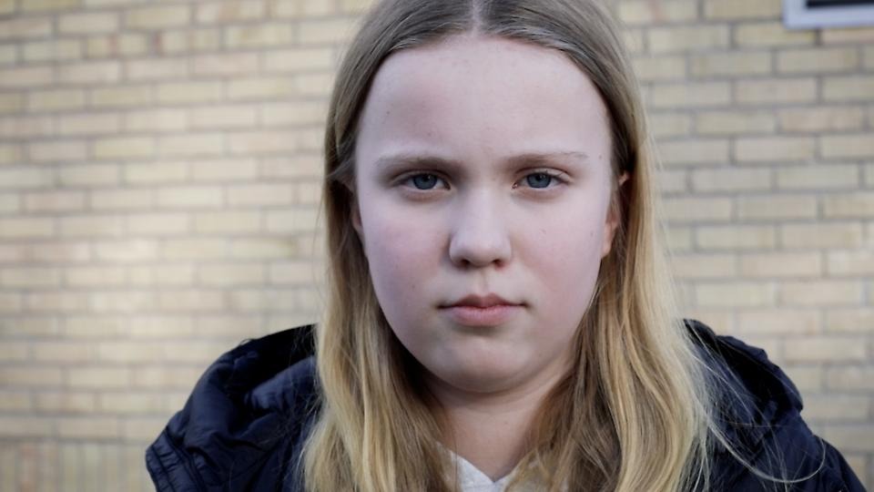 Närbild på flicka med blont hår, som ser ut att vara i mellanstadieålder.