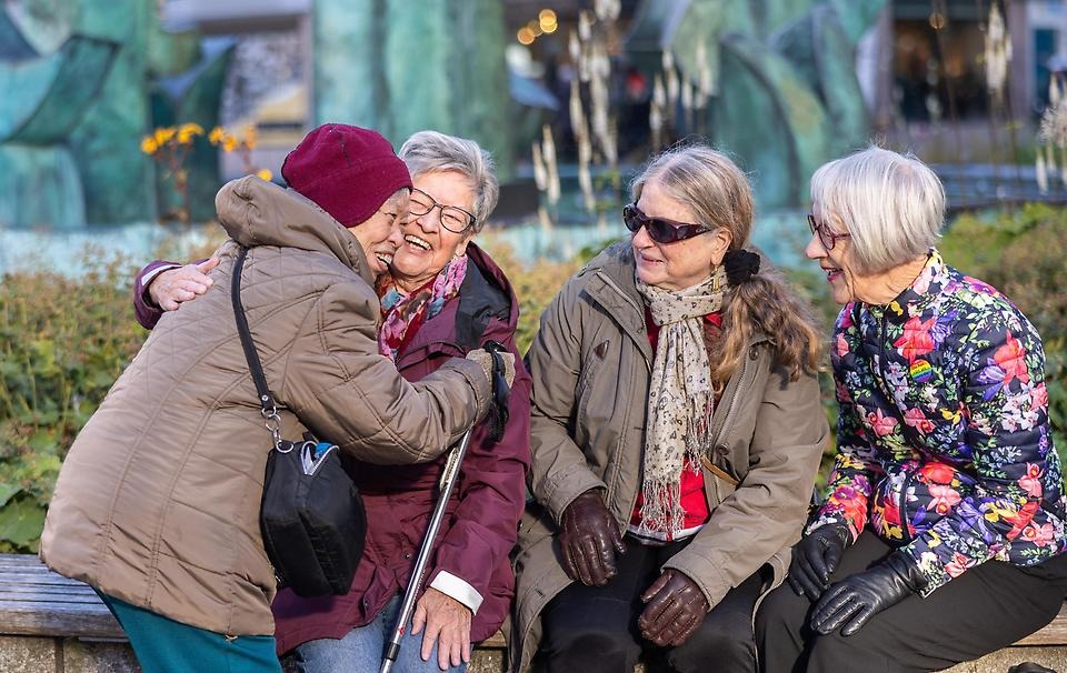 En grupp glada vänner träffs och kramas