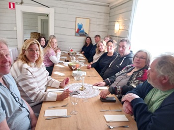 13 personer sitter vid ett långbord på restaurang.
