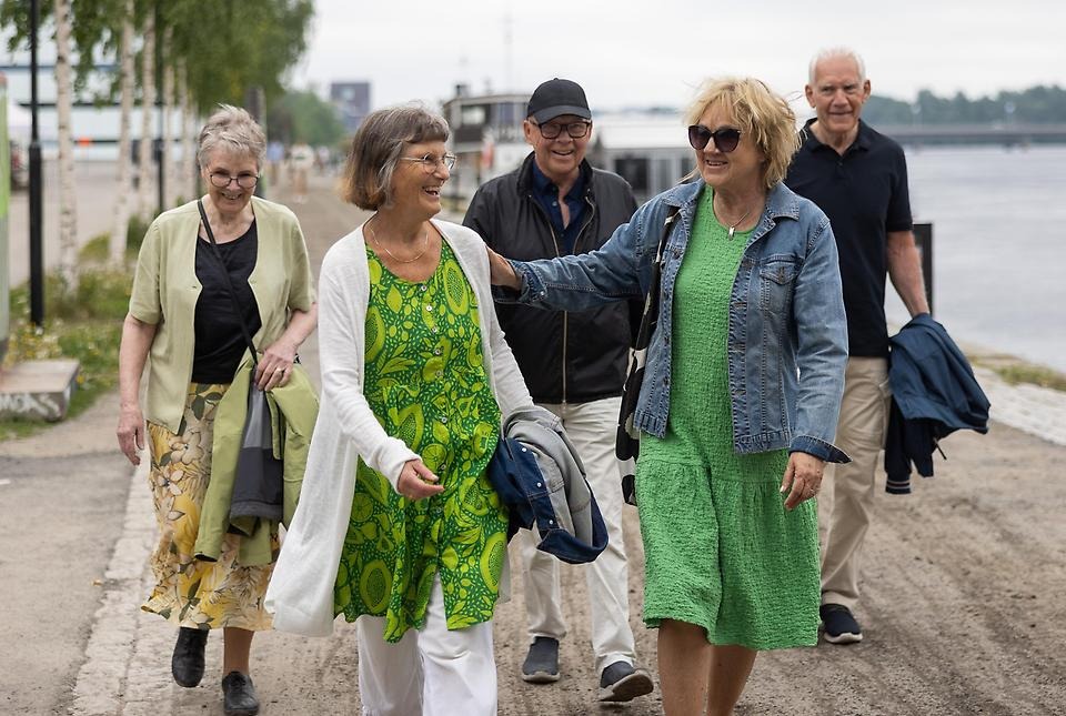 Glada människor promenerar längs strandpromenaden