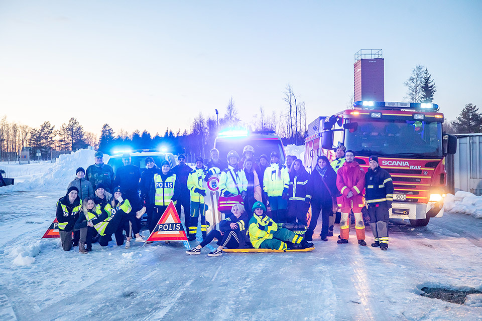 Deltagare vid Människan bakom uniformen som står framför en polisbil, en ambulans och en brandbil.