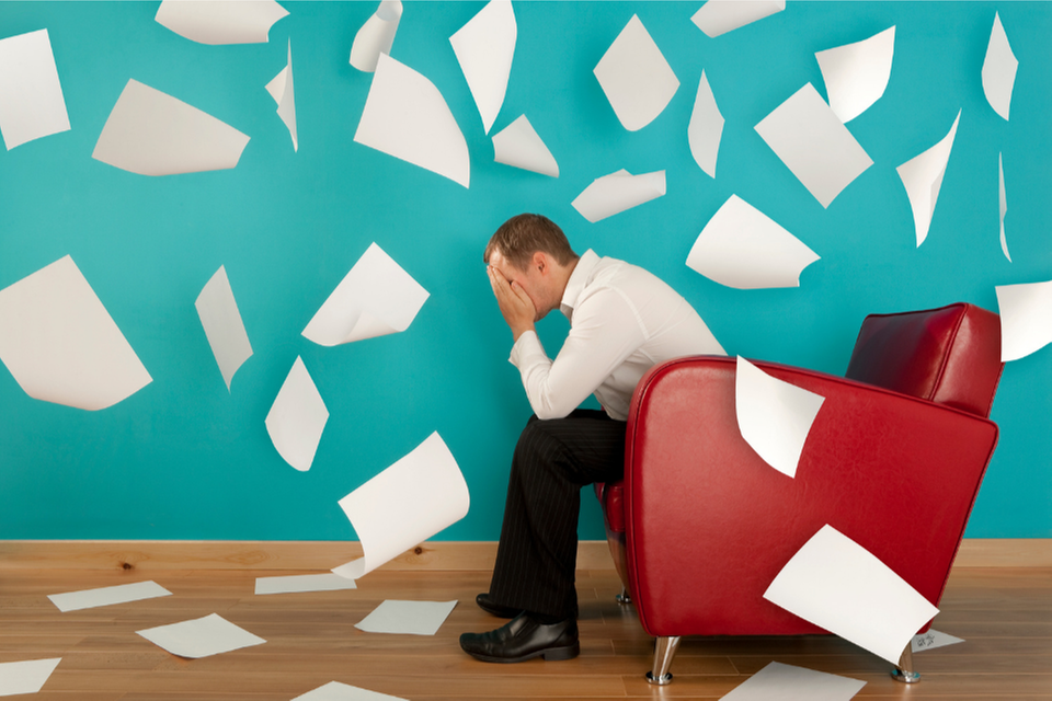 Animerad bild på en man i en röd fåtölj med massor av pappersark flygandes i luften