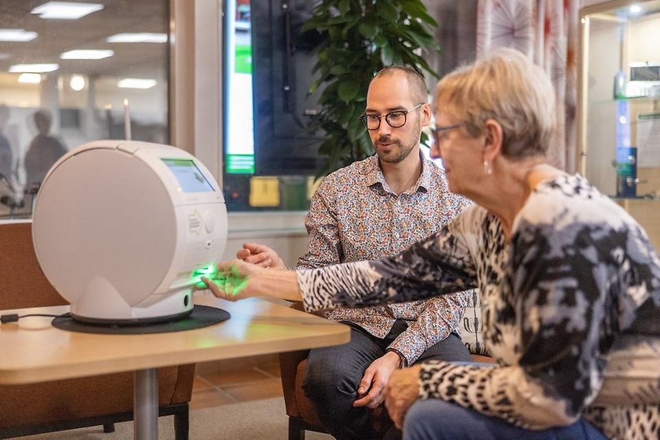 En man visar en kvinna hur en midicingivare fungerar.