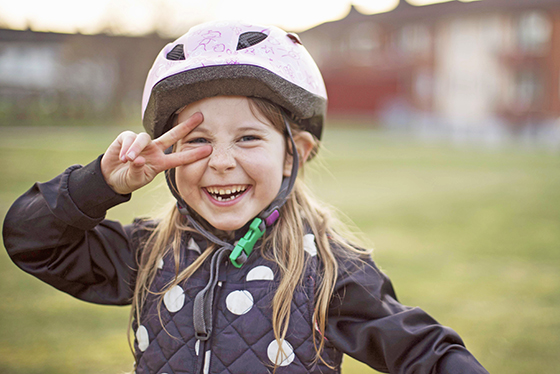 en glad flicka som är ute och cyklar