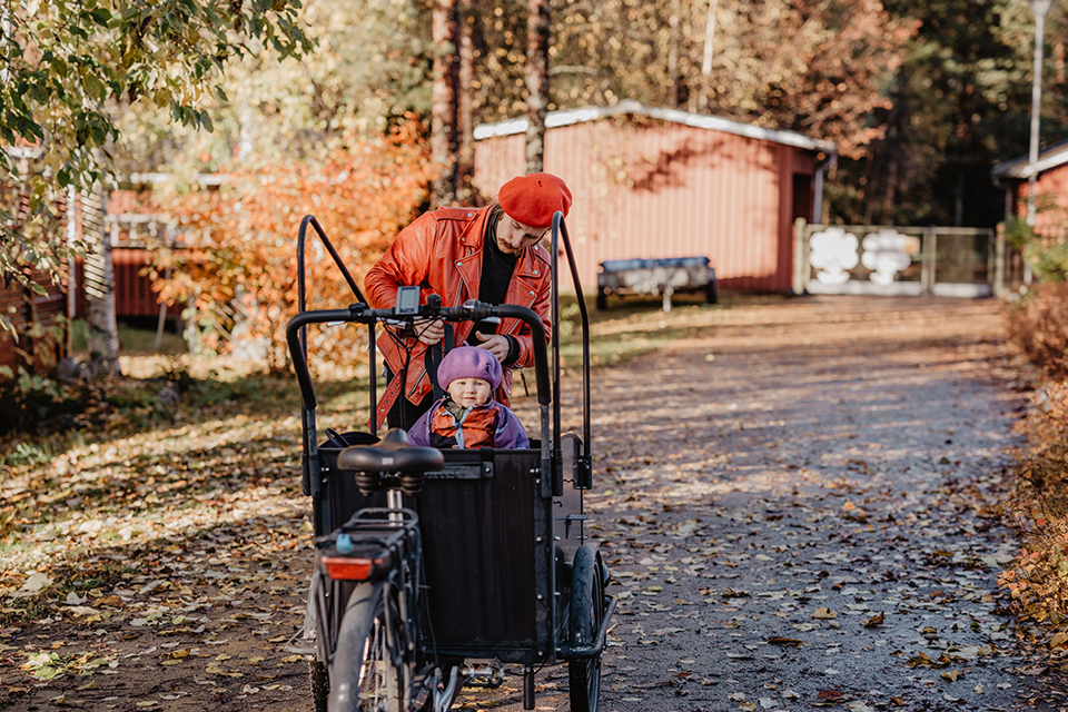 En pappa förbereder för en färd med lådcykel.