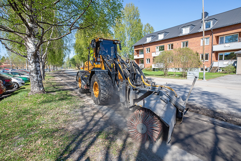 traktor skrapar en gata, villor