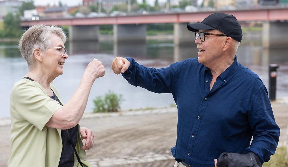 Två glada människor som gör "hige-five" med knuten hand.