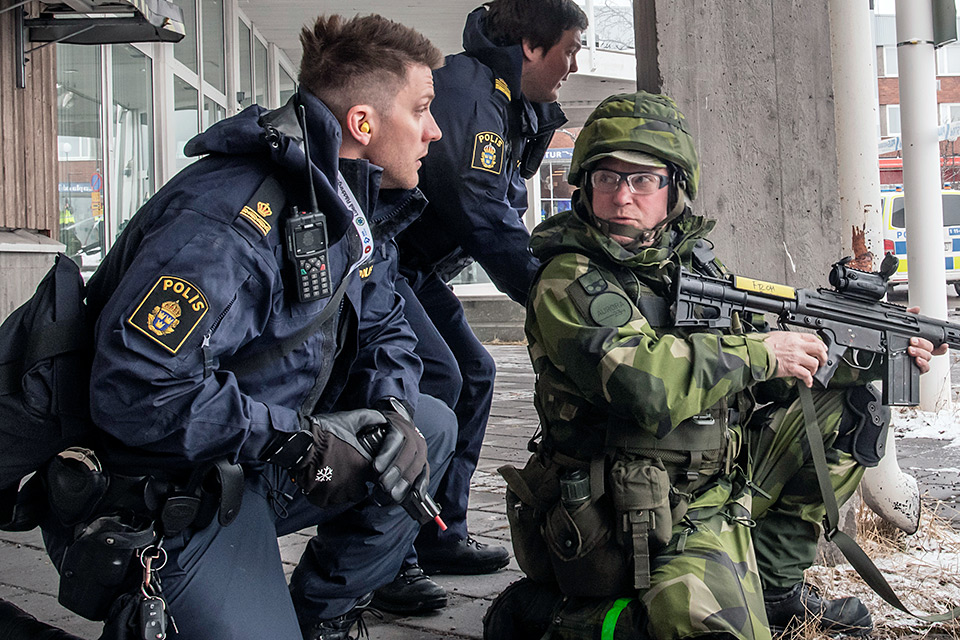 Hemvärnssoldat och poliser övar.