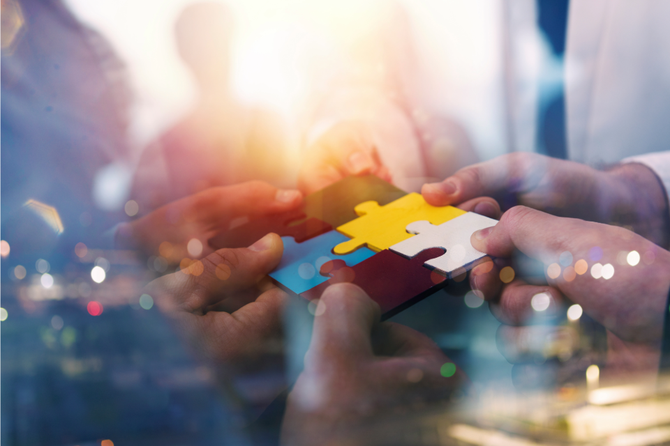 En man som står och pratar i telefon inomhus i hemmamiljö. 