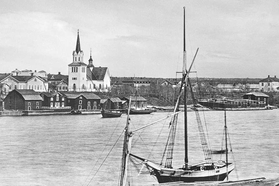 Historisk bild från Umeå före branden, tagen från tegssidan, med en segelskuta vid stranden