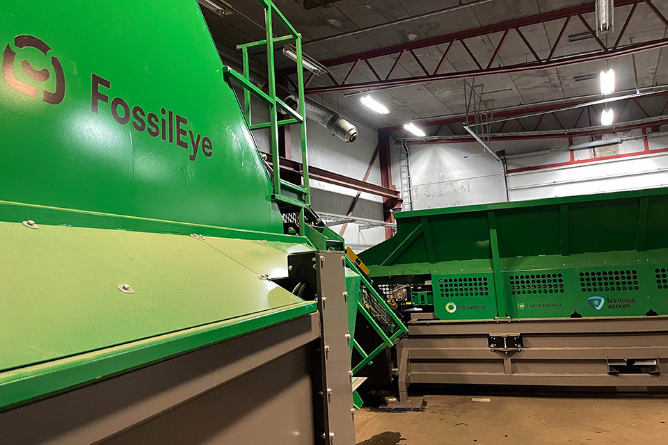 En stor grön maskin märkt “FossilEye” i en industriell miljö.
