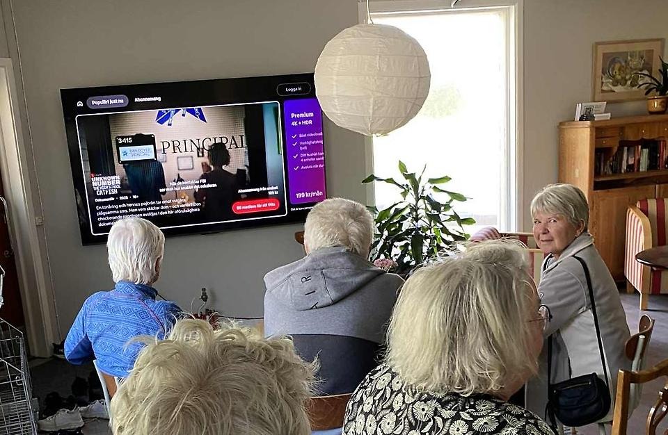 Seniorer sitter i en lokal i Överboda intresseförenings möteslokal Bodan och ser på en skärm