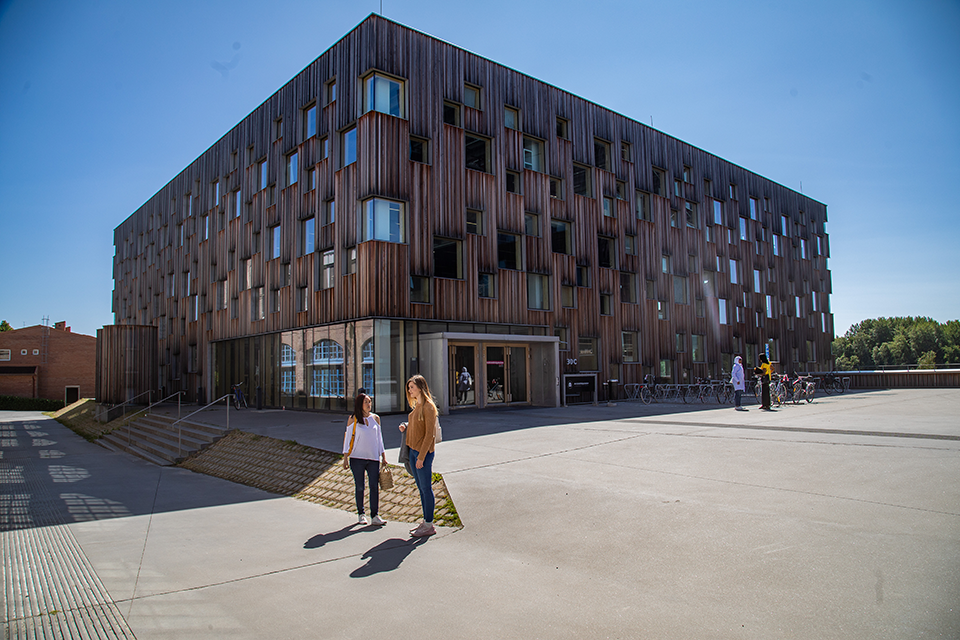 Bilden visar studenter som rör sig utomhus vid Konstnärligt campus