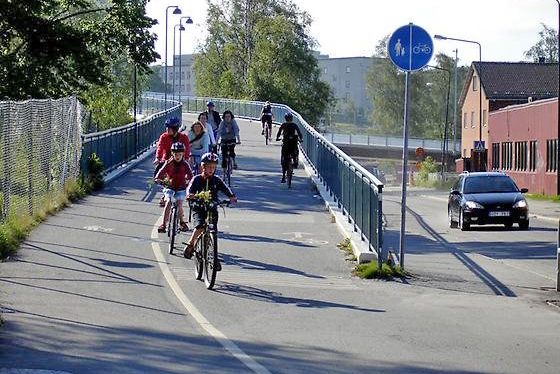 barn cyklar på cykelbana, bil, gata, hus