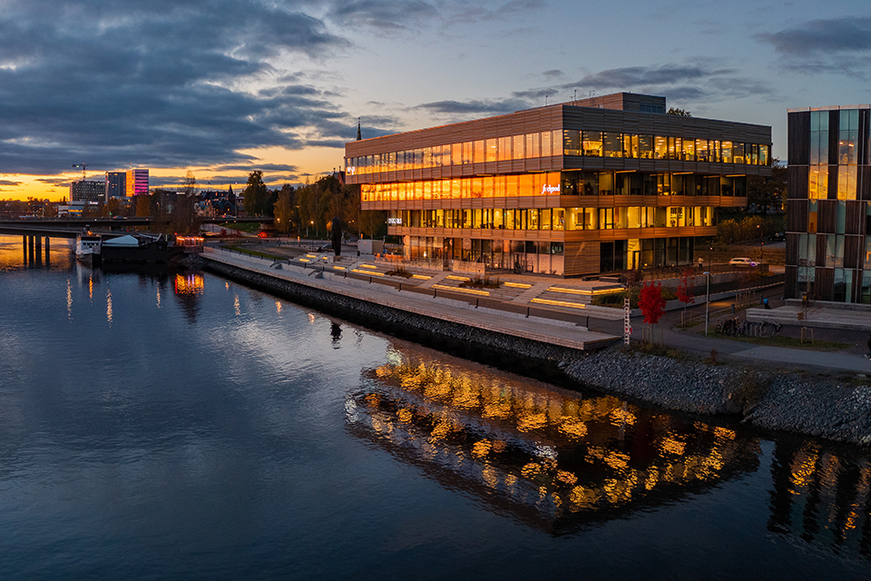 The image shows a view of modern architecure by the Umeå river.