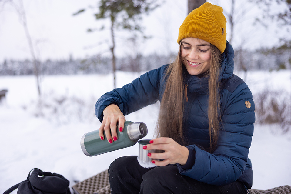 Bilden visar Olivia som dricker kaffe ur en termos.