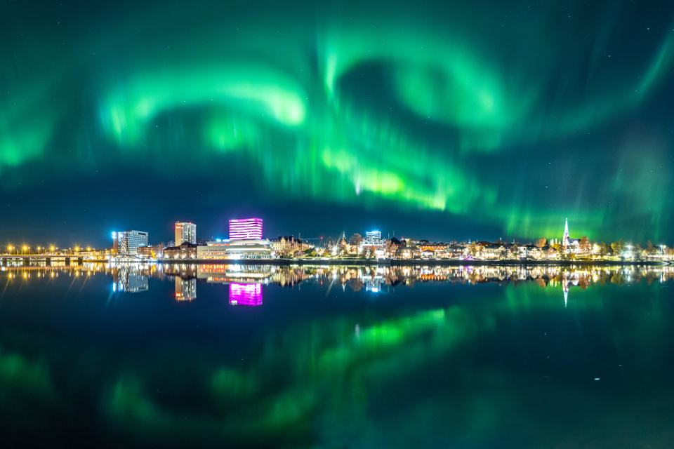 Kvällsvy över Umeå centrum i norrsken med fina färger.