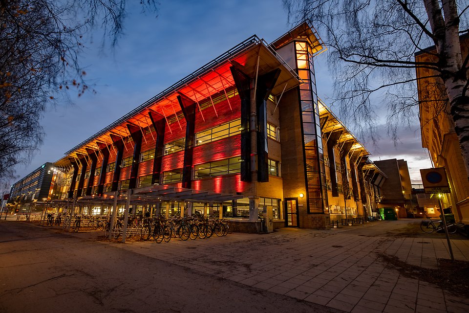 Parkeringshusets fasad i röd belysning på kvällen.