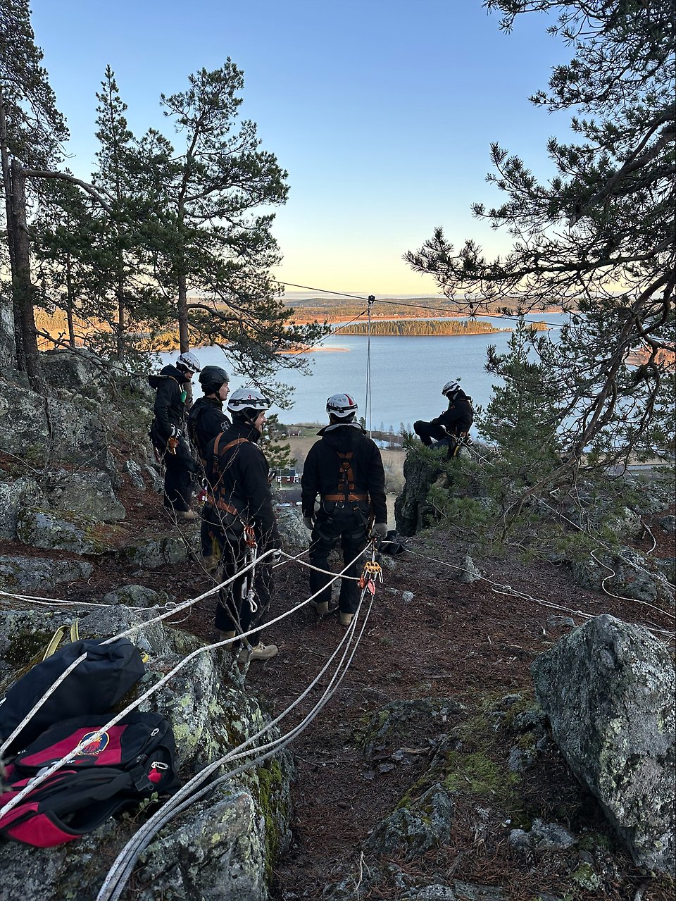 En grupp personer sitter på en gräsmatta.