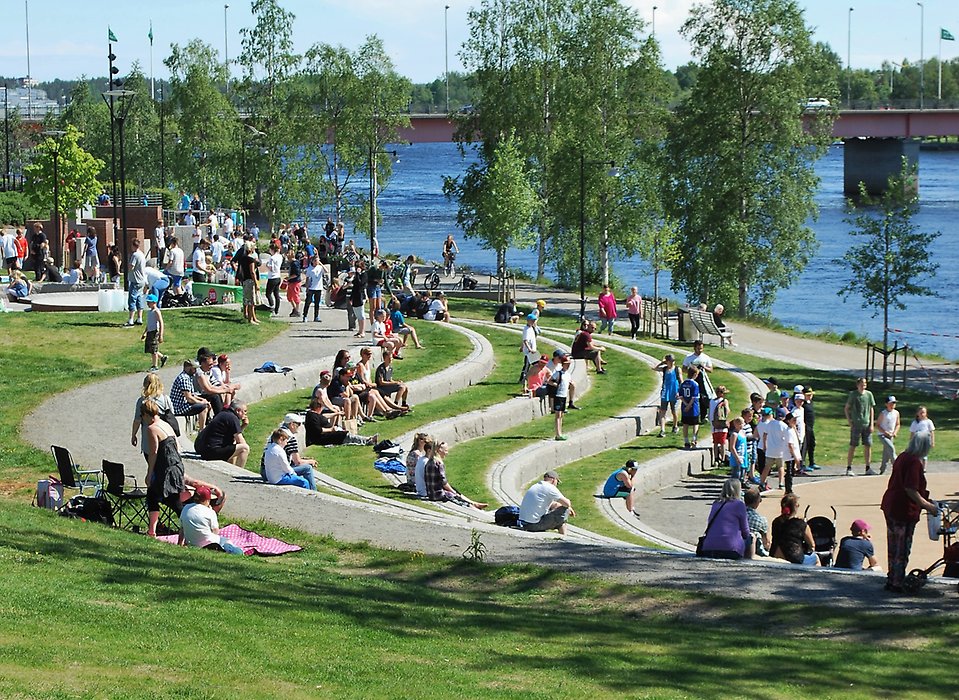 Människor i Broparken en solig sommardag.