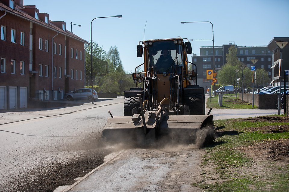 Traktor sopar sand, träd, hus