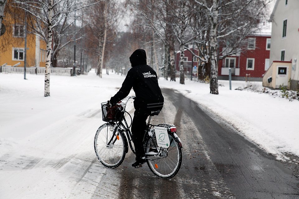 Hemtjänstpersonal på cykel en vinterdag.