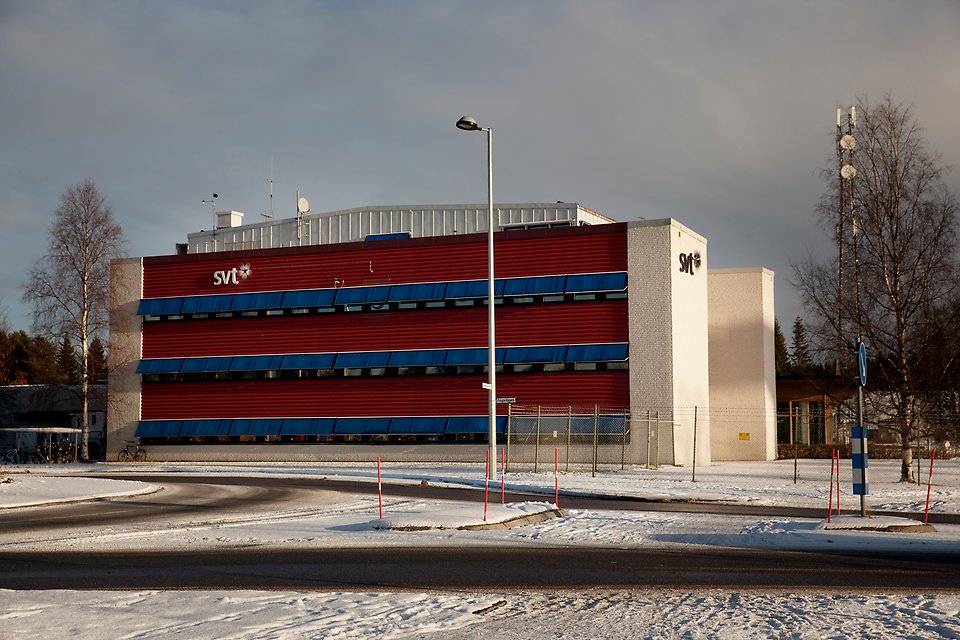 SVT-huset med fasad i rött och vitt, med blå markiser.
