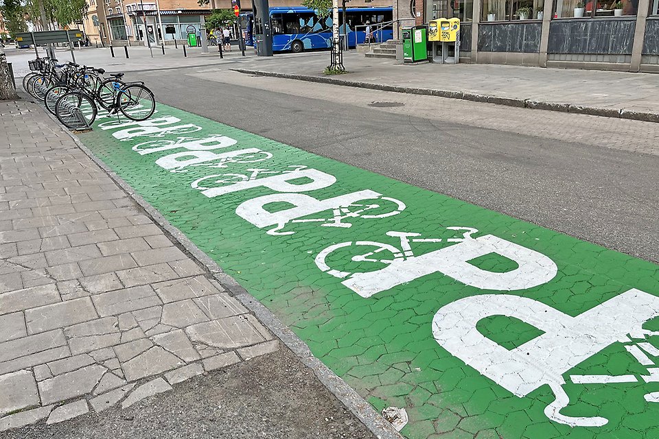 Parkeringsplatser för cyklar är tydligt uppmärkt med grön färg på gatan och vita symboler föreställande cyklar.