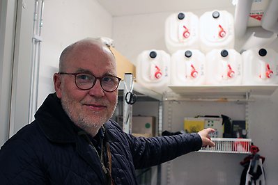 Man visar vattendunkar i ett förråd.