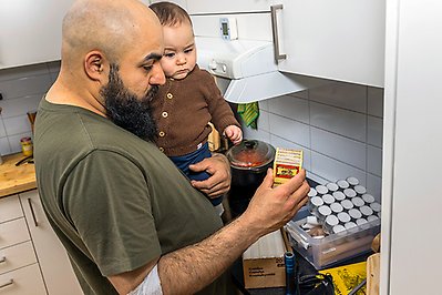 En man och en liten pojke med ljus och tändstickor i ett kök