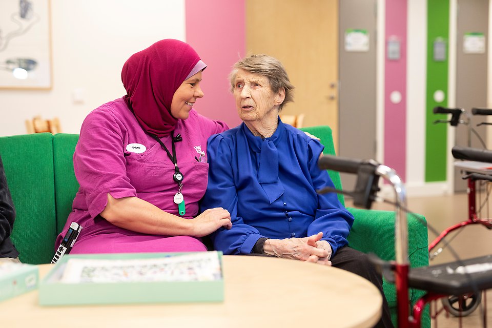 bilden visar en äldre kvinna och en undersköterska på ett äldreboende