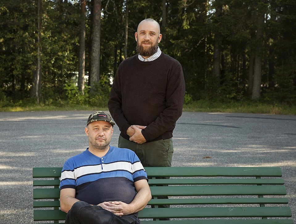 två män, en sittande och en stående