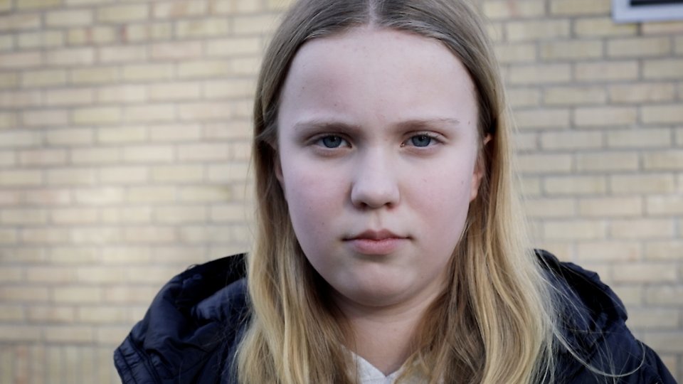 Närbild på flicka med blont hår, som ser ut att vara i mellanstadieålder.